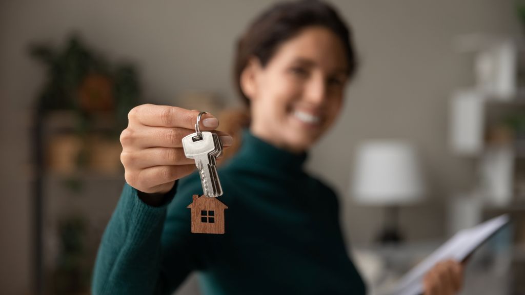 Woman holding house keys while preparing to buy a home.
